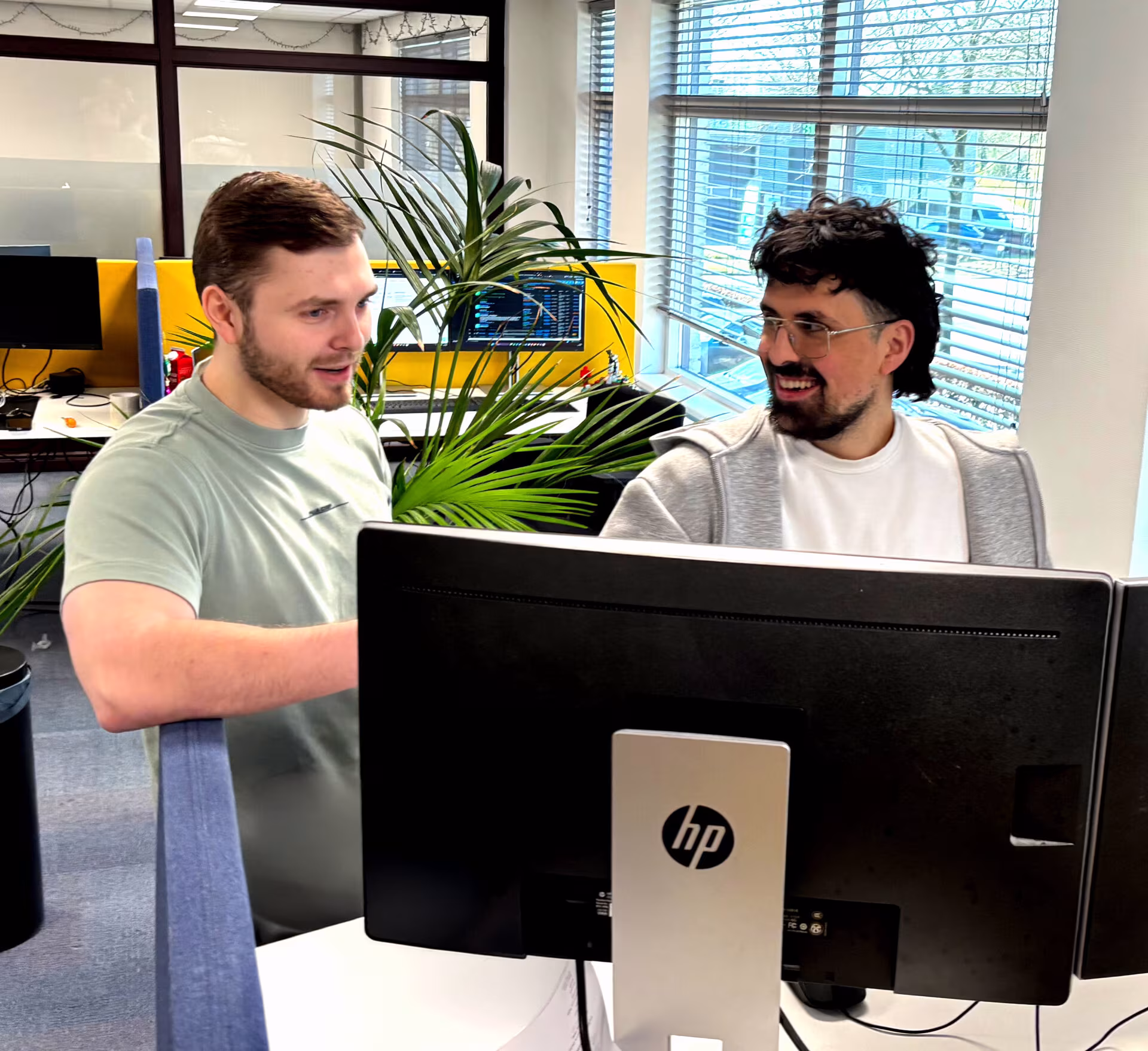 Twee collega’s van Techni Team overleggen achter een beeldscherm