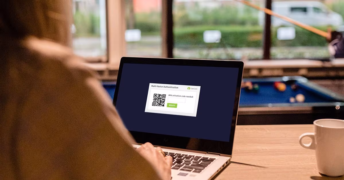 Laptop met een inlogscherm met QR-code, met op de achtergrond een pooltafel
