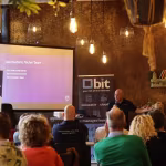 Presentatie over de geschiedenis van Techni Team voor een zaal met publiek tijdens het jubileum
