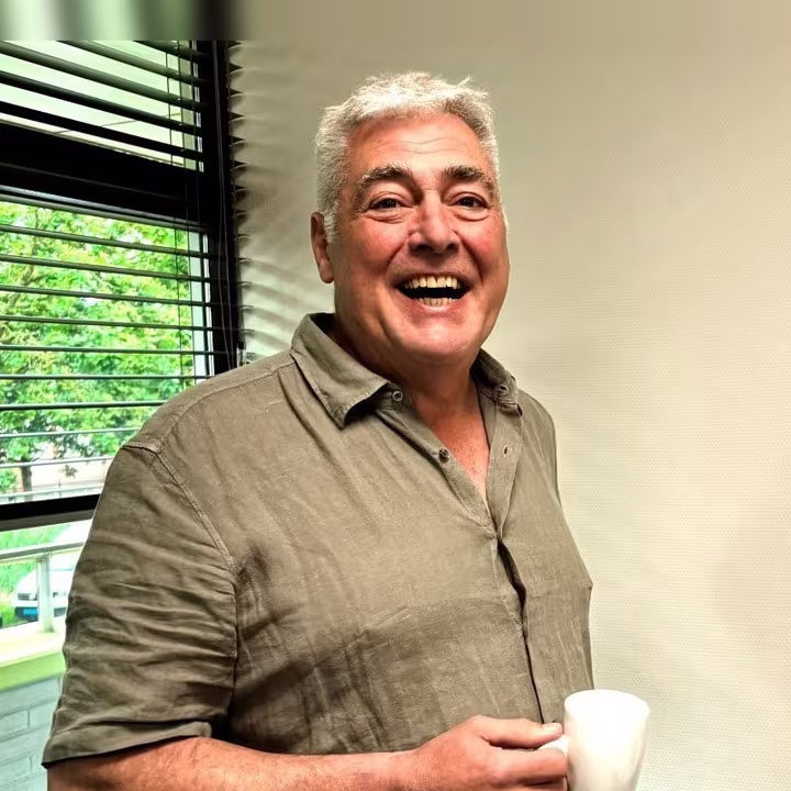 Dirk Bolte lacht met een kop koffie in zijn hand